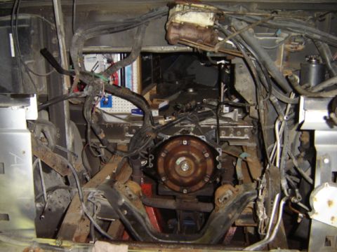 1992 Ford Bronco - The engine bay of a vehicle is shown with the transmission and extensive wiring harnesses visible.