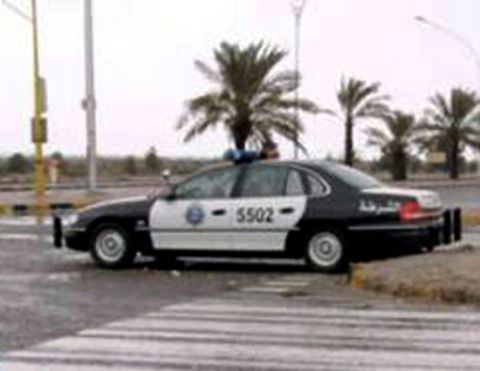 1999 Mercury Grand Marquis - A black and white police car is visible from the side, with Arabic text on the rear door and a number 5502 on the front door.