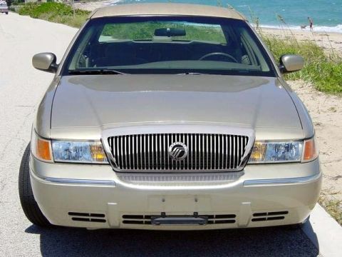 1999 Mercury Grand Marquis - Front view of a gold 1999 Mercury Grand Marquis parked near a beach.