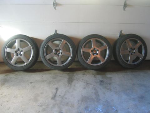 1993 Ford Probe - Four alloy wheels and tires are displayed against a garage door.
