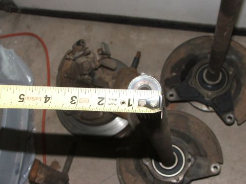 1965 Ford Mustang - A tape measure is used to measure the diameter of a car part, likely a brake rotor or axle housing.