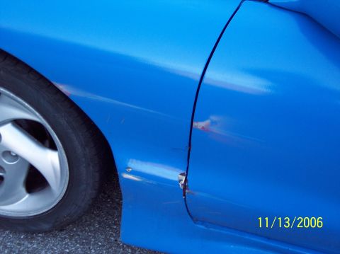 1995 Ford Probe - The image shows significant damage to the door and body panel of a blue vehicle.