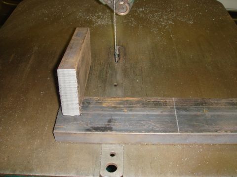 1996 Ford Bronco - Metal bar being cut on a band saw.