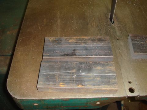 1996 Ford Bronco - Metal stock marked with measurements rests on a band saw table.