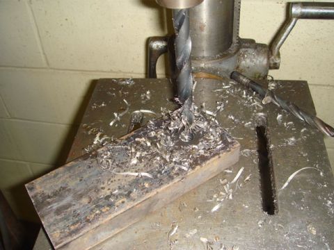 1996 Ford Bronco - Metal shavings cover the drill press table as a bit bores into a metal workpiece.