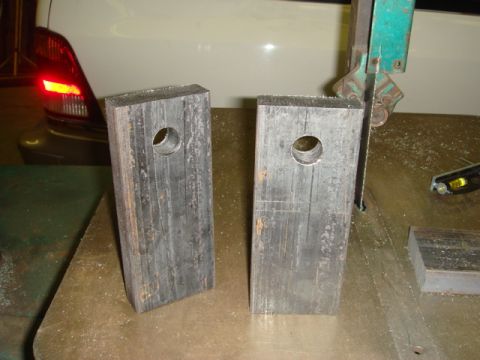 1996 Ford Bronco - Metal parts are being worked on in a shop, with a car's taillight visible in the background.