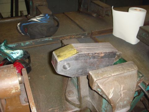 1996 Ford Bronco - A metal part is secured in a vise, ready for work. Other items are visible in the background.