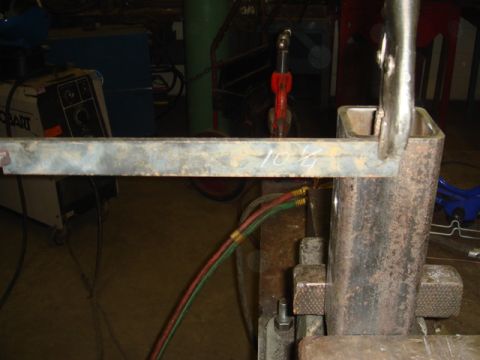1996 Ford Bronco - A metal bar is being measured and prepared for fabrication in a workshop setting.
