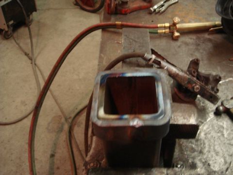 1996 Ford Bronco - Metal fabrication work in progress with a welding torch and various parts on a workbench.