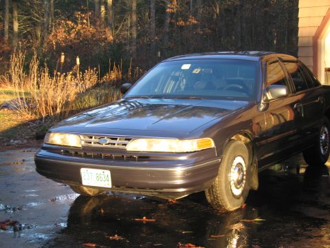 1991 Ford LTD Crown Victoria - A 1991 Ford Crown Victoria LTD is seen parked on a wet driveway in front of a garage.