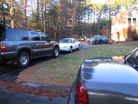 1991 Ford LTD Crown Victoria - A collection of vehicles are parked in a driveway on a sunny day.