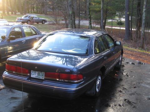 1991 Ford LTD Crown Victoria - A dark blue 1991 Ford Crown Victoria LTD sedan is parked in a driveway with another similar vehicle behind it.