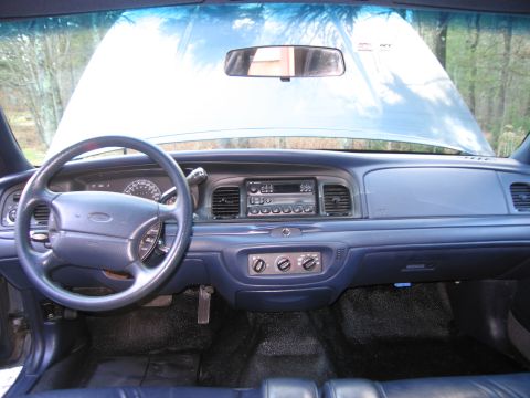 1991 Ford LTD Crown Victoria - The interior of a car with the hood open, showing the dashboard and steering wheel.