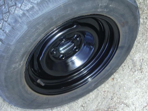 1996 Ford Crown Victoria - Close-up of a spare tire mounted on a black steel wheel.