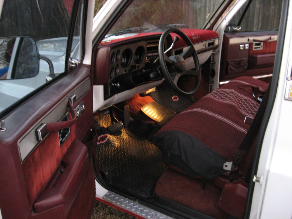 Interior of a white truck with maroon seats and door panels. View shows dashboard and steering wheel