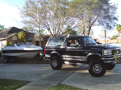 1995 Ford Bronco - A black 1995 Ford Bronco is shown towing a white boat on a trailer.