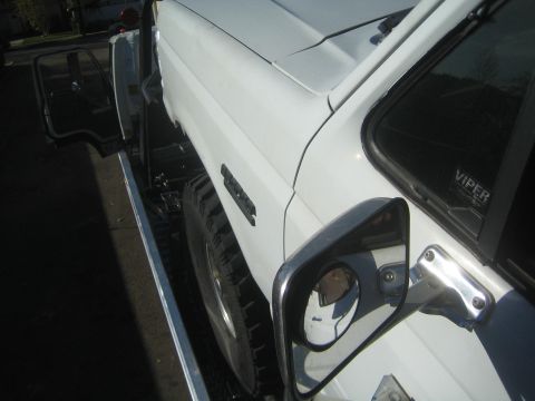 1990 Ford Bronco - Side view of a white SUV, large side mirrors and a Viper sticker on the passenger window.