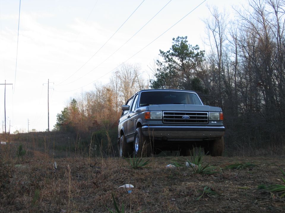 1989 Ford Bronco parked on grassy incline