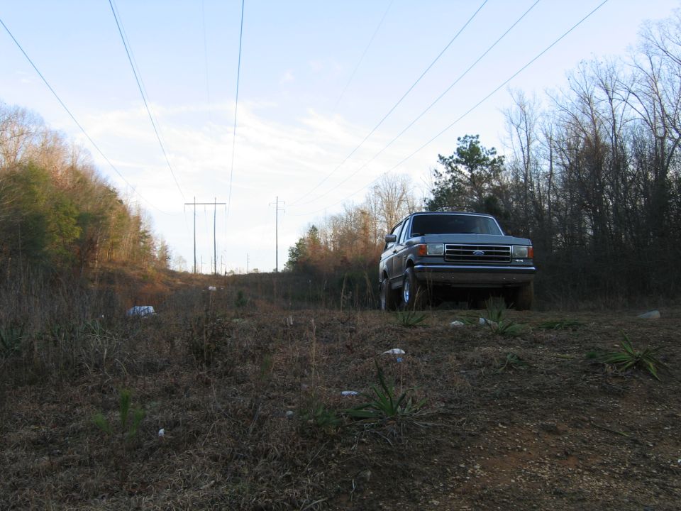 Gray Ford Bronco parked on a dirt hill with power lines overhead