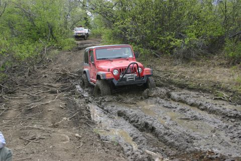 2003 Jeep TJ - Two Jeeps tackle a challenging muddy off-road path.