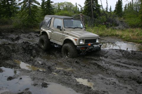 2003 Jeep TJ - A Suzuki Samurai navigates a challenging muddy terrain.