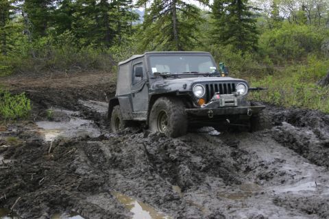 2003 Jeep TJ - Jeep TJ struggling through deep mud on an off-road trail.