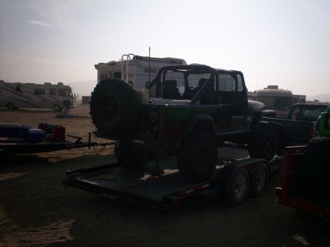 1987 Suzuki Samurai - A modified Jeep Wrangler is loaded onto a trailer at an outdoor event with RVs parked nearby.