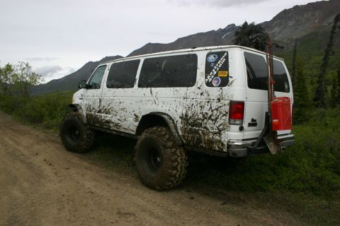 2003 Jeep TJ - This heavily modified van appears to have seen some rough terrain, evidenced by the extensive mud coverage.