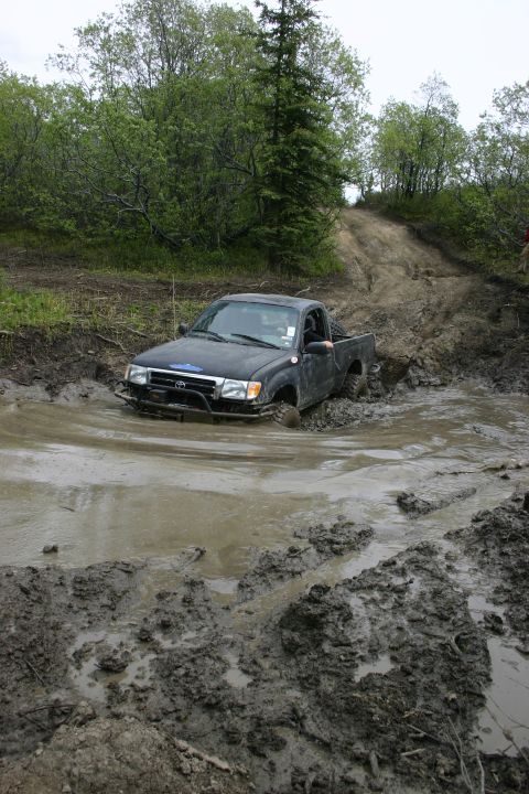 2003 Jeep TJ - Toyota Tacoma struggles through a muddy off-road trail.