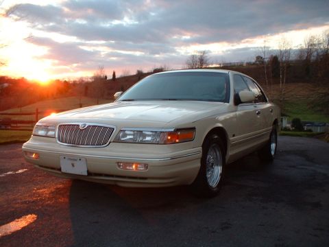 1996 Mercury Grand Marquis - A tan 1996 Mercury Grand Marquis is parked outside during a sunset.