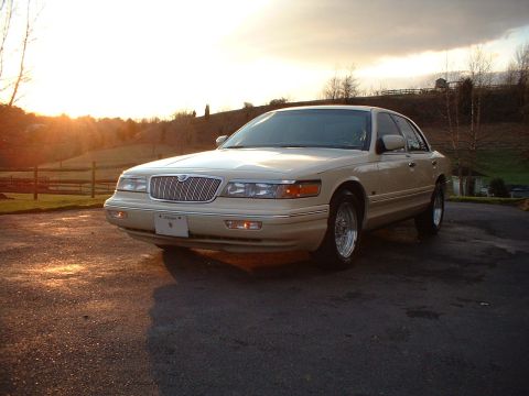 1996 Mercury Grand Marquis - A 1996 Mercury Grand Marquis sedan is viewed from the front-right at sunset, parked on a driveway.