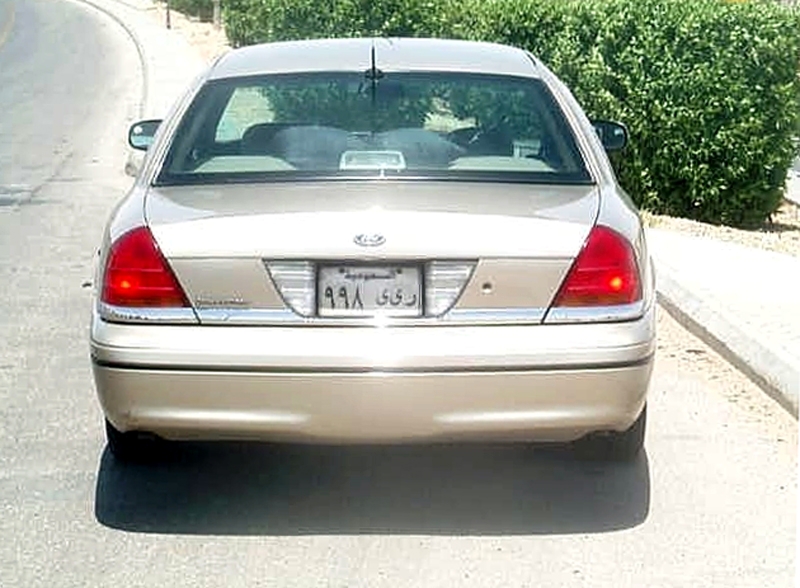 Rear view of a gold Ford Crown Victoria with Arabic license plate roadside
