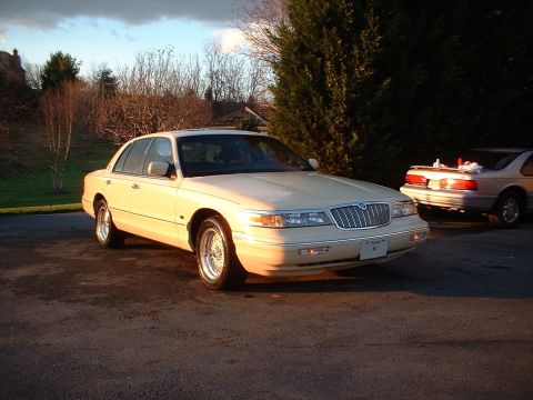 1996 Mercury Grand Marquis - Sedan parked on asphalt with another vehicle in the background under a cloudy sky.
