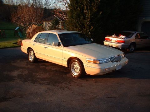 1996 Mercury Grand Marquis - A 1996 Mercury Grand Marquis is parked in a driveway during golden hour, with another vehicle visible behind it.