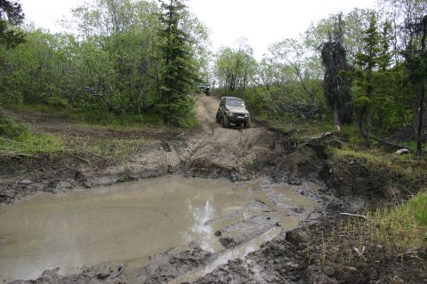 2003 Jeep TJ - Off-road vehicles tackle a challenging muddy trail during an Alaska meet and greet event.