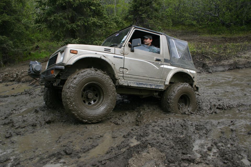 Suzuki Samurai stuck in deep mud on a trail