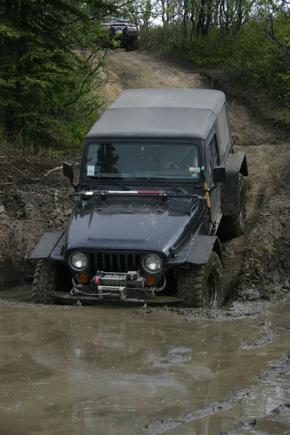 Black Jeep Wrangler TJ stuck in mud on a trail, 2003 model
