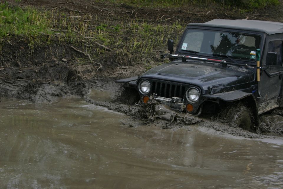 Black Jeep Wrangler deep in mud, front end submerged