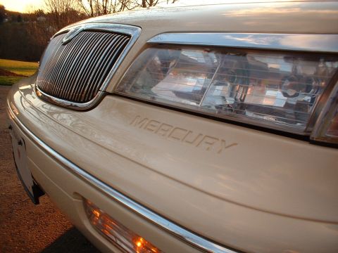 1996 Mercury Grand Marquis - The front of a cream-colored Mercury Grand Marquis is shown with its distinctive grille and headlights.