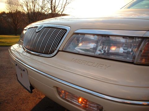 1996 Mercury Grand Marquis - Close-up of the front of a cream-colored vehicle, highlighting the grille and 'Mercury' text.