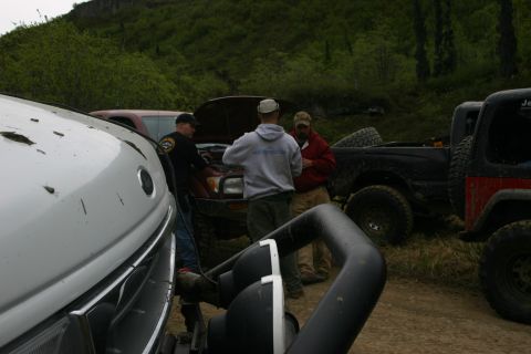 2003 Jeep TJ - A group of people gather around a Jeep TJ with its hood open during an off-road event.