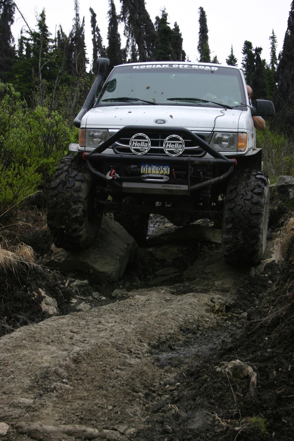 White van with snorkel and big tires on rocky trail