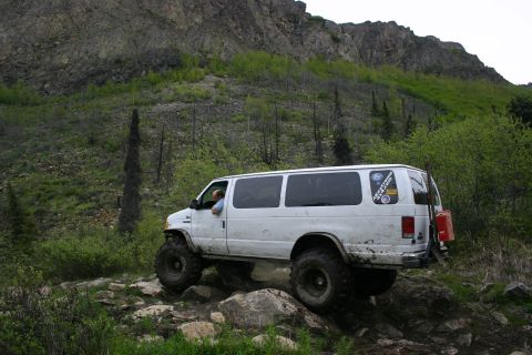2003 Jeep TJ - White van navigates a challenging rocky trail in a mountainous, wooded area.