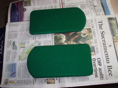 1994 Ford F-150 - Two green upholstered parts are laid out on newspapers, possibly for a vehicle interior project.