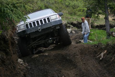 2003 Jeep TJ - A silver Jeep Grand Cherokee tackles a challenging off-road trail during an event.