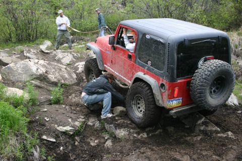 2003 Jeep TJ - A red Jeep Wrangler TJ navigates a challenging rocky terrain during an off-road event.