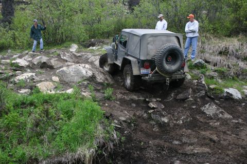 2003 Jeep TJ - A Jeep TJ navigates a challenging off-road course with onlookers present.