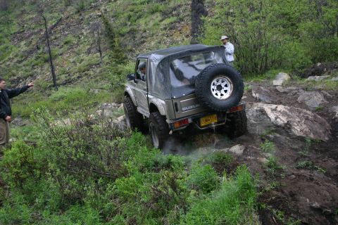 2003 Jeep TJ - Suzuki Samurai tackling a challenging rocky incline on an off-road trail.