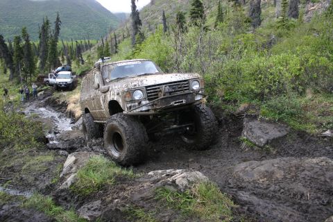 2003 Jeep TJ - Multiple off-road vehicles tackle a challenging, muddy mountain path during an Alaska 4x4 Meet & Greet.