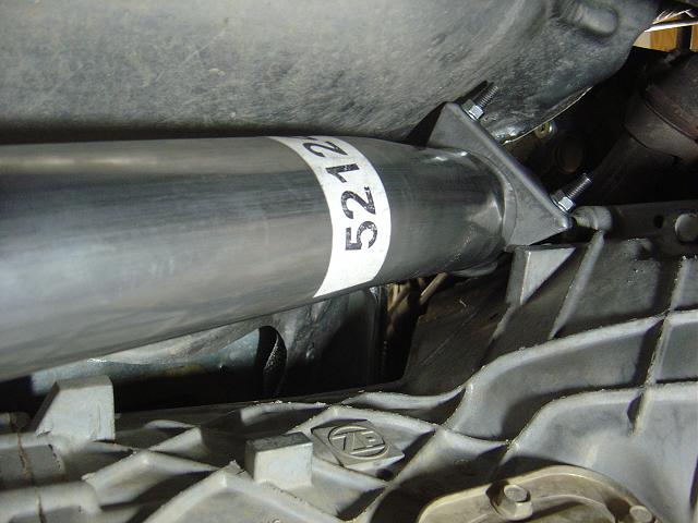 Close-up of exhaust pipe with a white band labeled '5212' and part of a transmission housing